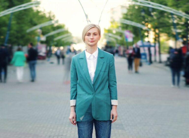 devojka pozira u sakou i farmerkama na ulici