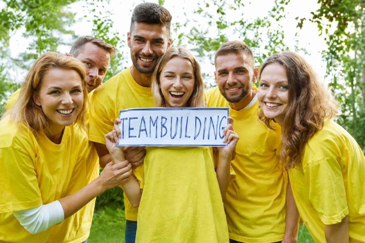 Nasmejani tim na team building aktivnosti u prirodi kao primer iskustvenog korporativnog poklona