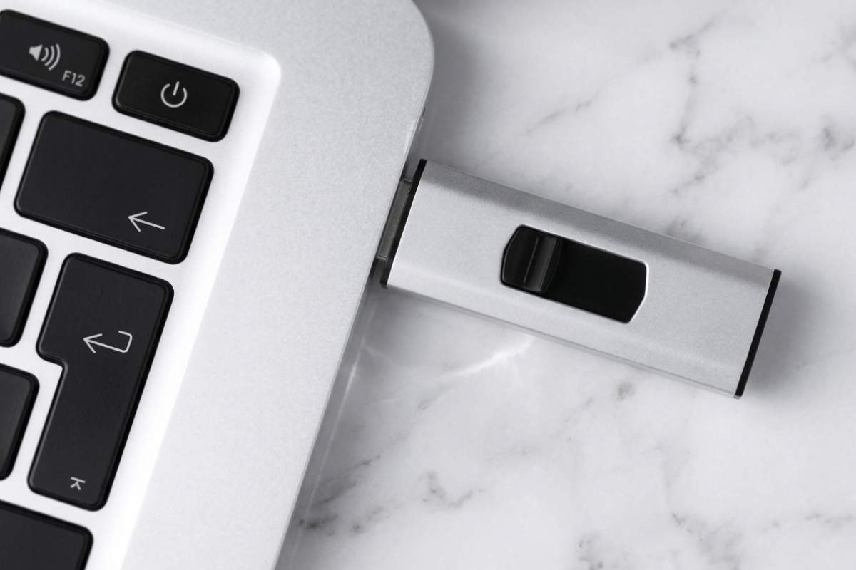 USB memorija povezana sa laptopom kao primer modernog kancelarijskog aksesoara za korporativni poklon